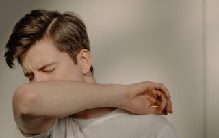 Man Covering His Face Sneezing