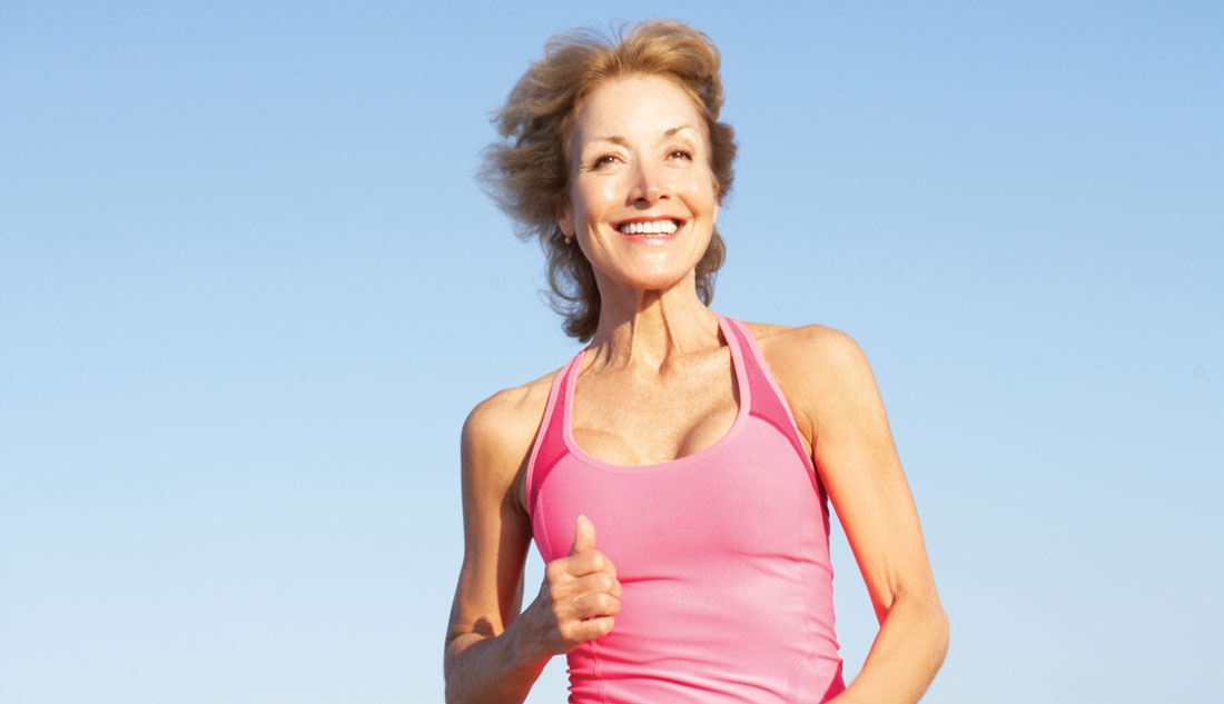Senior Woman Exercising On Beach